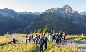 Eine Gruppe von Wanderern genießt die Aussicht auf die Berge. Der Himmel ist klar und die Natur bietet eine beeindruckende Kulisse. | © OK-Bergbahnen