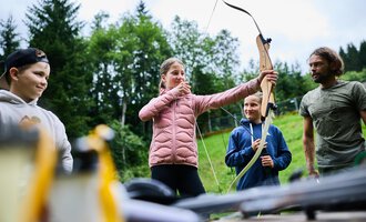 A logo of the Wilderness School Kleinwalsertal. It shows a fire over logs and symbolizes adventure in nature. | © Kleinwalsertal Tourismus eGen - Fotograf: Oliver Farys