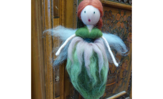Eine handgemachte Fee mit roten Haaren und buntem Kleid aus Filz. Sie hat einen zarten Körper und kleine Flügel. | © Maria Möckel, Der Kleinwalsertaler Rosenhof