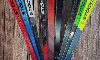 Eine Auswahl an Skiern von Stöckli in verschiedenen Farben. Die Skier stehen aufrecht und zeigen ihre markanten Designs. | © Austrian Ski- & Service Ranch | Trixi Leitner