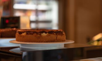 A delicious cake on a plate in a bakery. The cake has a golden crust and an appetizing filling. | © Campingplatz Vorderboden GmbH | Marion Schwendiger