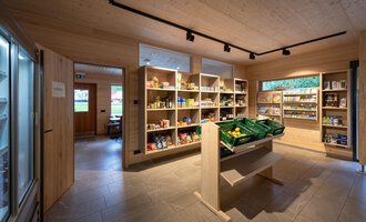 Ein kleiner Lebensmittelladen mit Regalen voller Produkte. Die Wände sind aus Holz, und das Licht ist hell und einladend. | © Campingplatz Vorderboden GmbH | Marion Schwendiger