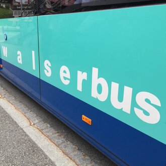 Ein Bus mit der Aufschrift „walserbus“. Die Farben des Busses sind türkis und blau. | © Kleinwalsertal Tourismus
