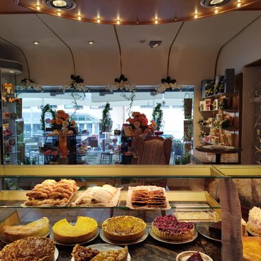 Eine gemütliche Bäckerei mit einer Auswahl an süßen und herzhaften Backwaren. Im Hintergrund sieht man Tische und Stühle für Gäste. | © Kleinwalsertal Tourismus | N. Lughammer