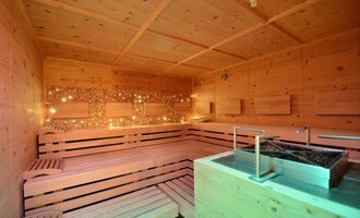 A cozy sauna with a wooden bench and soft lighting. The room radiates relaxation and warmth. | © Hotel Alpenstüble KG | Manuel Riezler
