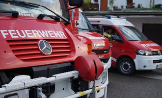A red fire truck is standing next to an ambulance. Both vehicles are marked with important emergency services. | © Feuerwehr Mittelberg | Christoph Hilbrand