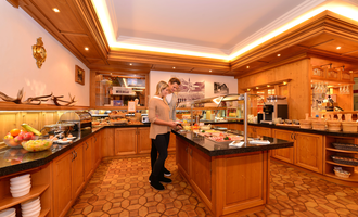 A stylish buffet in a cozy restaurant. Two people enjoy the selection of food and drinks. | © Hotel Alpenstüble KG