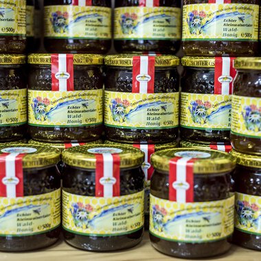 Eine Vielzahl von Gläsern mit Marmelade ist gestapelt. Die Gläser haben bunte Etiketten mit dekorativen Designs. | © Kleinwalsertal Tourismus | Dominik Berchtold