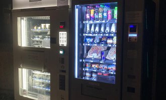 Ein Verkaufsautomat in der Dunkelheit mit einer Vielzahl von Snacks und Getränken. Der Automat leuchtet und bietet eine bunte Auswahl für die Kunden. | © Gerd am Herd | Gerd Hammerer