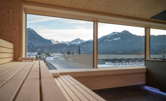 Eine moderne Wellness-Oase inmitten von Bergen und Wald. Menschen entspannen in einer harmonischen Umgebung mit grünen Pflanzen und einem klaren Himmel. | © Tourismus Oberstdorf