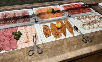 Ein reichhaltiges Buffet mit verschiedenen Sorten von Aufschnitt und Fisch. Frische Zutaten sind ansprechend auf Platten angerichtet. | © Almhof Rupp | Lukas Kind