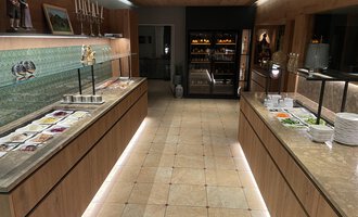 An elegant buffet area with light wooden cabinets and a varied selection of dishes. The soft lighting creates an inviting atmosphere. | © Almhof Rupp | Lukas Kind
