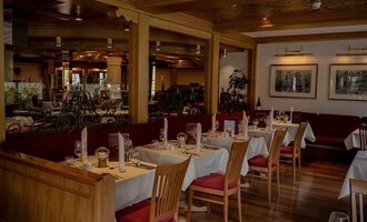 Ein gemütliches Restaurant mit Tischen und Stühlen aus Holz. Die Einrichtung ist warm und einladend, ideal für eine angenehme Mahlzeit. | © IFA Hotel Alpenhof Wildental