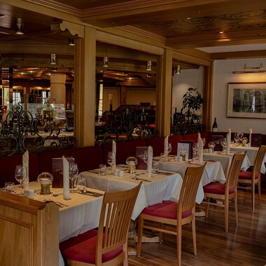 A cozy restaurant with wooden tables and chairs. The decor is warm and inviting, perfect for a pleasant meal. | © IFA Hotel Alpenhof Wildental