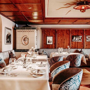 Ein elegantes Restaurant mit Holzvertäfelungen und stilvollen Tischen. Die gemütliche Atmosphäre wird durch die dekorativen Bilder und die geschmackvolle Einrichtung verstärkt. | © Hotel Birkenhöhe | Sascha Gast