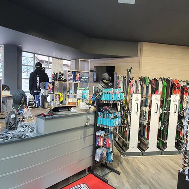 A sports store with ski and snowboard equipment. In the background, sunglasses and other accessories are offered. | © Ski + Sport Zunzer Mittelberg