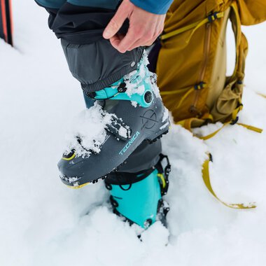Ein Mann repariert Skiausrüstung und montiert einen Skischuh. Im Hintergrund stehen zahlreiche Ski. | © Kleinwalsertal Tourismus | Oliver Farys
