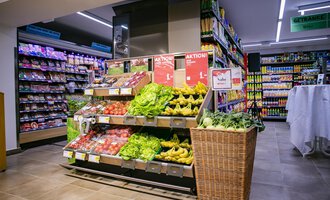 A fresh fruit and vegetable stand in a supermarket with various types. The shelves in the background are filled with food. | © SPAR