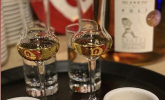 Ein Tablett mit zwei Tassen Espresso und zwei Gläsern Likör steht bereit. Im Hintergrund ist eine Flasche Sarpa zu sehen. | © Uusziit | Chantal Kessler