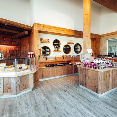 A modern store with plenty of wooden decor and shelves full of products. The cozy atmosphere invites browsing. | © XOND | Jodok Fritz