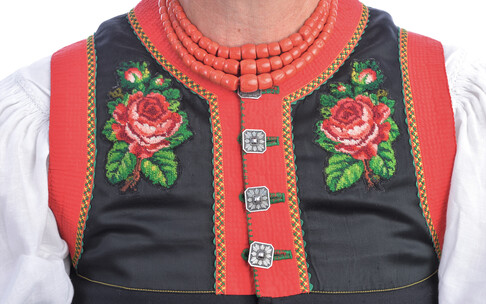 "Hämdärmel" (blouse), visible part of the "Onderrock" (underskirt) with rose embroidery and four buttons and "Halsbaater" (coral necklace) | © Kleinwalsertal Tourismus |Photographer: Christoffer Leitner
