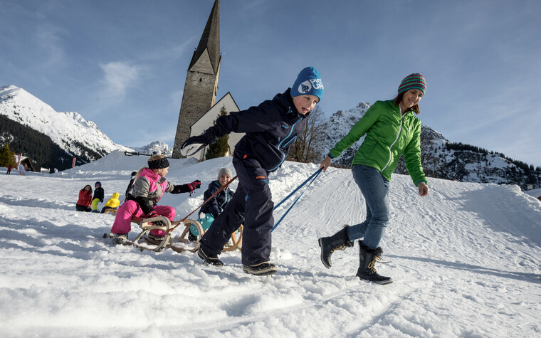 Family at sledding | © Kleinwalsertal Tourismus eGen | Photographer: Dominik Berchtold