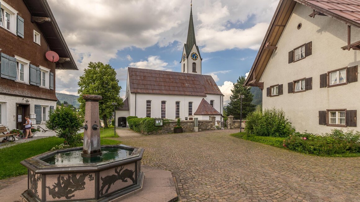 Pfarrkirche Hirschegg Dorfbrunnen | © Kleinwalsertal Tourismus | Steffen Berschin