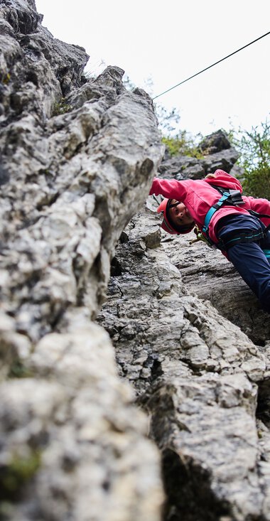 Person beim Klettern an einer Felswand bei Bergschule Kleinwalsertal, Sommer 2023. | © Kleinwalsertal Tourismus eGen • Fotograf: Oliver Farys
