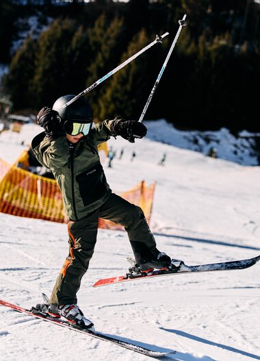 A child skiing in winter on a slope, wearing a helmet, ski goggles, and winter clothing. | © Kleinwalsertal Tourismus eGen • Photographer: Oliver Farys