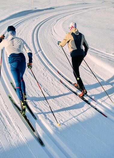 Zwei Skifahrer im klassischen Skilanglauf auf einer schneebedeckten Loipe im Kleinwalsertal, Schwarzwasserloipe, während der Winter-2025-Saison. | © Kleinwalsertal Tourismus eGen • Fotograf: Oliver Farys