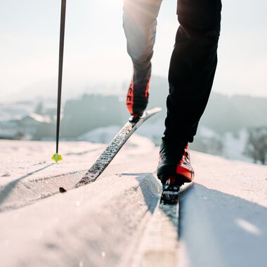 Cross-country skier in classic technique on Schwarzwasserloipe in Kleinwalsertal, in a winter landscape with skis and poles. | © Kleinwalsertal Tourismus eGen • Photographer: Oliver Farys