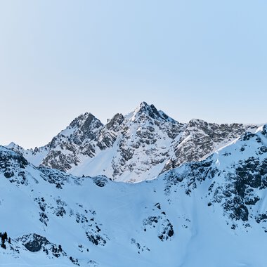 A snowy mountain landscape with rugged peaks under a clear blue sky in Kleinwalsertal, Austria. | © Kleinwalsertal Tourismus eGen • Fotograf: Oliver Farys