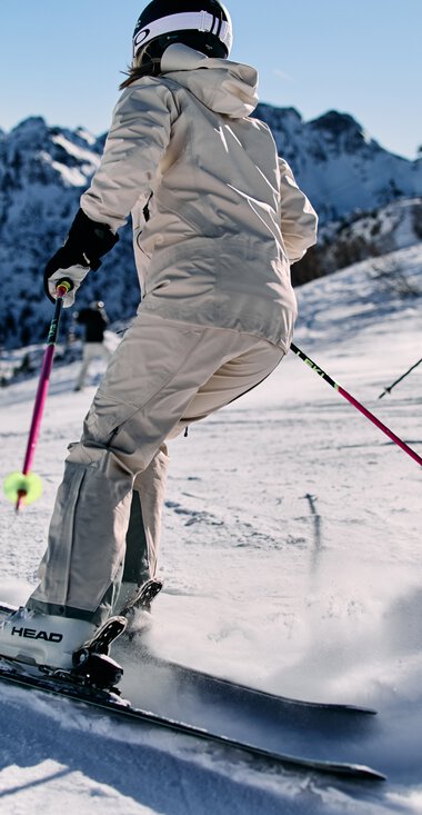 Zwei Skifahrer unterwegs auf der Piste am Kanzelwand mit Bergpanorama im Hintergrund. | © Kleinwalsertal Tourismus eGen • Fotograf: Oliver Farys