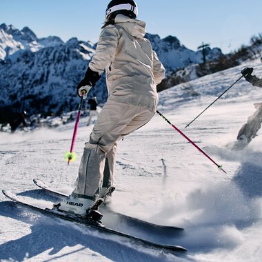 Two skiers on the slope at Kanzelwand with mountain scenery in the background. | © Kleinwalsertal Tourismus eGen • Photographer: Oliver Farys