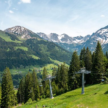 Mountain station of a cable car in the Alps with mountains, forests, and a ski lift in Oberstdorf, Germany. | © Oberstdorf · Kleinwalsertal Bergbahnen