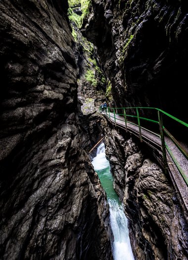 Fascinating view of Breitachklamm with steep rocky walls and a small metal bridge. | © Kleinwalsertal Tourismus eGen • Breitachklamm • Photographer: Dominik Berchtold