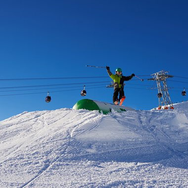 A skier jumps in the air on a snowy mountain at the ski lifts in Oberstdorf, Germany. | © Kleinwalsertal Tourismus eGen • Oberstdorf Kleinwalsertal Bergbahnen
